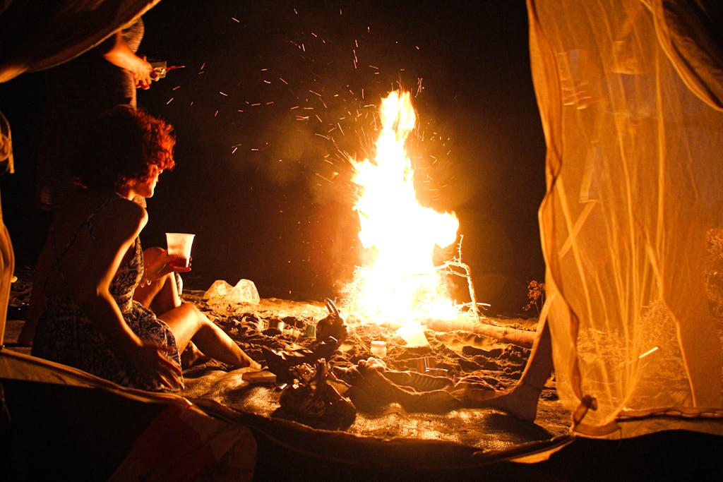 Cozy night scene of friends enjoying a beach campfire under the stars.